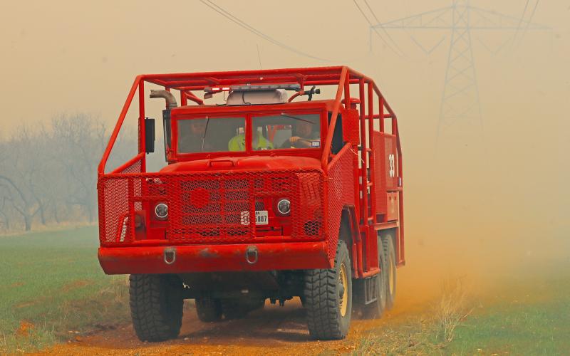 (THOMAS WALLNER | THE GRAHAM LEADER) A Murray Volunteer Fire Department brush truck arrives Friday, March 14 to assist other county volunteer fire units fight a grass fire near the transmission lines off of Fish Creek Road. Dust and smoke filled the air as volunteers units fought gusts of wind. 