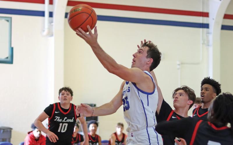 (THOMAS WALLNER | THE GRAHAM LEADER) Ty Thompson jumps over Levelland players Saturday, Dec. 14 to score a layup during crossover play of the Red, White & Blue Tournament in Graham.