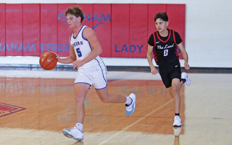 (THOMAS WALLNER | THE GRAHAM LEADER) Steers player Cooper Corley dribbles down the court and looks for a an open player to pass to during the Saturday matchup against Levelland in the Red, White & Blue Tournament. 