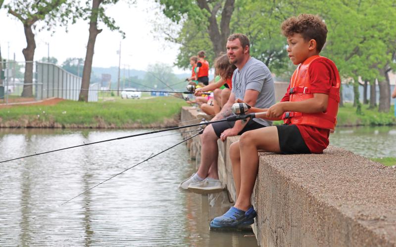 (ARCHIVE PHOTO | THE GRAHAM LEADER) Visitors to the Family Fun and Fishing event in 2024 fish in the Firemen’s Park pond as part of an annual tournament. During the event, free fishing poles, bait and life jackets are distributed for participants to keep.