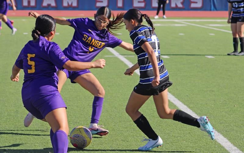 (ALEX HAVARDANSKY | THE GRAHAM LEADER) Brianna Hernandez tries to break away from defenders Friday, Dec. 12 against the Sanger Lady Indians. The Lady Blues’ offense surged in their first scrimmage match, winning by a final score of 8-0. 