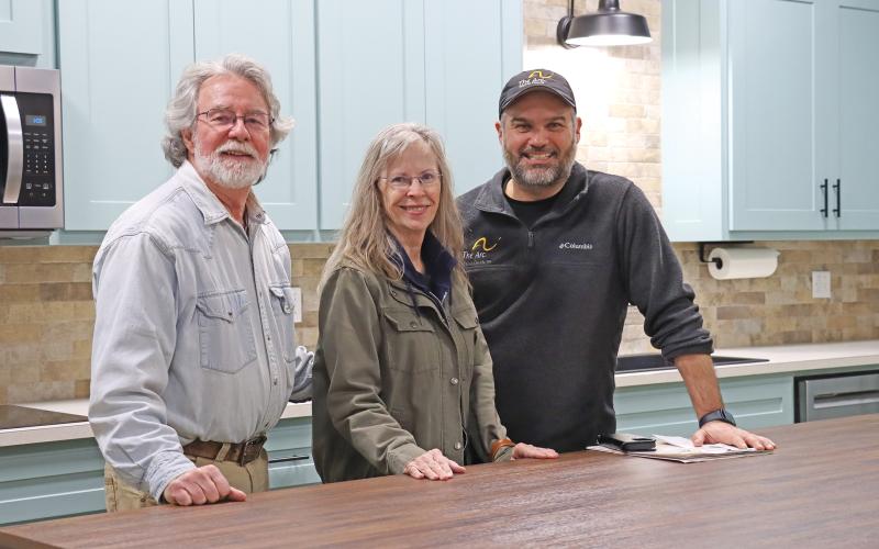 (THOMAS WALLNER | THE GRAHAM LEADER) Dennis and Andy Heath sit behind a counter with The Arc of Wichita County Executive Director Anthony Watkins (right) at the Hero House. The renovated kitchen area is one of the features of the Intellectual and Developmental Disabilities day habilitation facility.