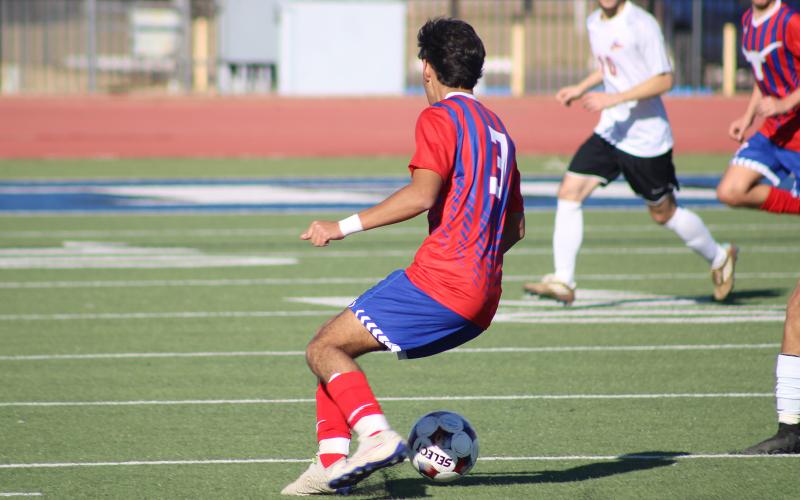 (ALEX HAVARDANSKY | THE GRAHAM LEADER) Eric Martinez changes direction with the ball to evade defenders Friday, Dec. 12 against the Sanger Indians. Head coach Tim Wankowicz said the team settled down in the second half to finish the game strong. 