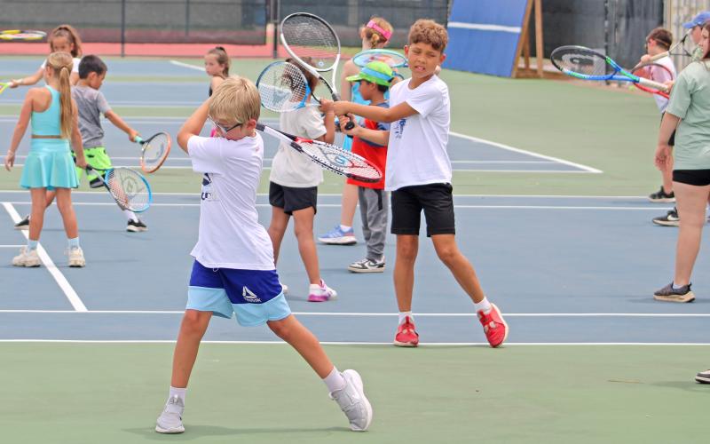 (ALEX HAVARDANSKY | THE GRAHAM LEADER) Steers and Lady Blues campers practice their swing form during Graham tennis camp Tuesday, June 10. Younger campers took the morning sessions while older campers took the afternoon sessions.