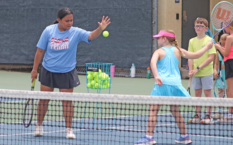 (ALEX HAVARDANSKY | THE GRAHAM LEADER) Lady Blues high school players assist campers during tennis camp Tuesday, June 10. The goal of this camp according to coach Matt Birdwell is to inspire interest in the campers for the sport in hopes they return to it in the future.