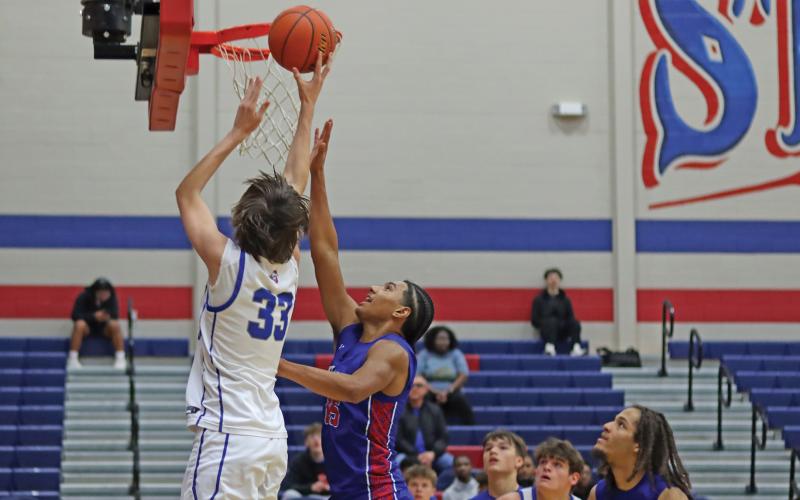(THOMAS WALLNER | THE GRAHAM LEADER) Nikolas Wankowicz uses his height to his advantage by jumping over an Abilene Cooper player to make a layup shot during the home game Friday, Jan. 3. The team fought hard in the second half of the game but fell to the Cougars.