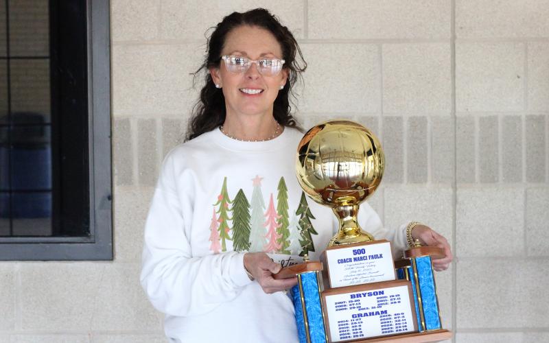(ALEX HAVARDANSKY | THE GRAHAM LEADER) Marci Faulk stands with her gold ball celebrating reaching the 500th career win mark. Faulk has served as the head coach for both the Graham Lady Blues and Bryson Cowgirls volleyball teams throughout her career. 