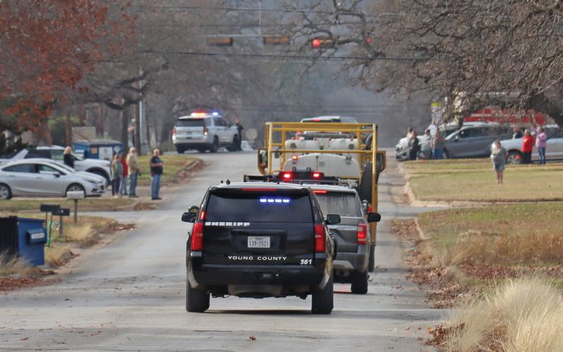 (THOMAS WALLNER | THE GRAHAM LEADER) Community members stand down First Street as former chief Dennie Covey is transported to Morrison’s Funeral Home by local first responders.