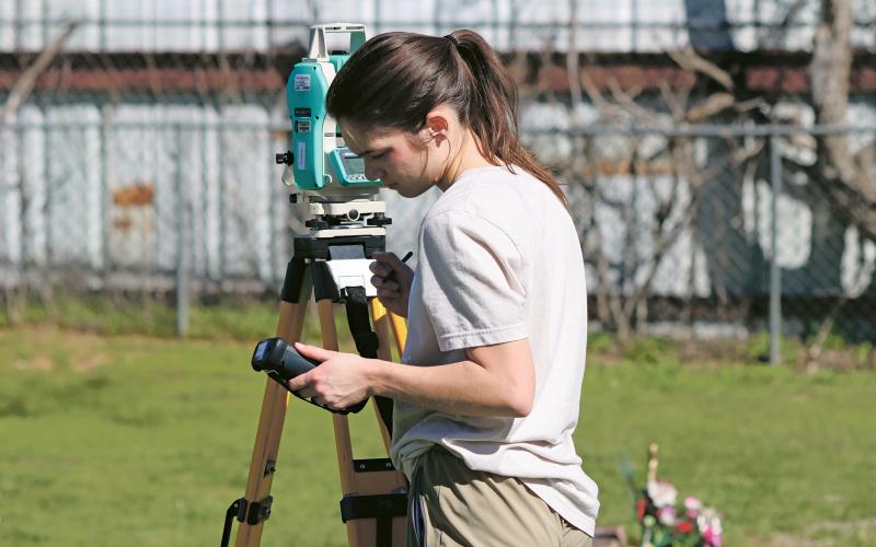 (KYLIE BAILEY | THE GRAHAM LEADER) Graduate student Abby Sink checks some of her equipment during the first day of the Texas Tech University archaeological study at the Oak Grove Colored-William P. Johnston Memorial Cemetery.