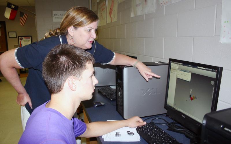 (ARCHIVE PHOTO | THE GRAHAM LEADER) Clark Miracle reverse engineers a small motor with a little help from his teacher Michelle Lowrey in May 2012. Miracle was part of the Project Lead the Way engineering curriculum and advanced to national competition in the Technology Student Association.