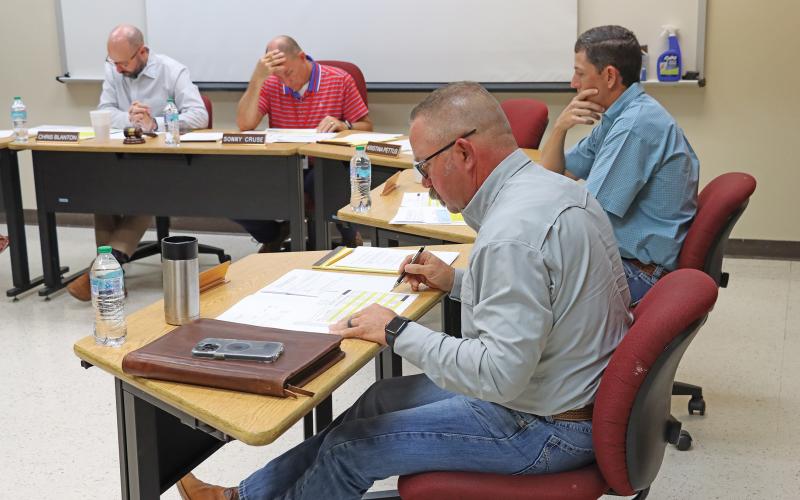(THOMAS WALLNER | THE GRAHAM LEADER) Members of the Graham ISD Board of Trustees look over the proposed budget Wednesday, Aug. 28 after a public hearing was held for the budget and tax rate. Shown from left to right are Board President Chris Blanton, Superintendent Sonny Cruse, Jason Smith (front) and Brandon Joy.