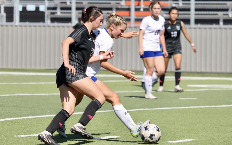 (THOMAS WALLNER | THE GRAHAM LEADER) Ava Street keeps the ball away from the Canyon Randall Lady Raiders during the Lady Blues’ bi-district matchup Thursday, March 19 in Burkburnett. The team won in a penalty shootout and moved on to the area round.