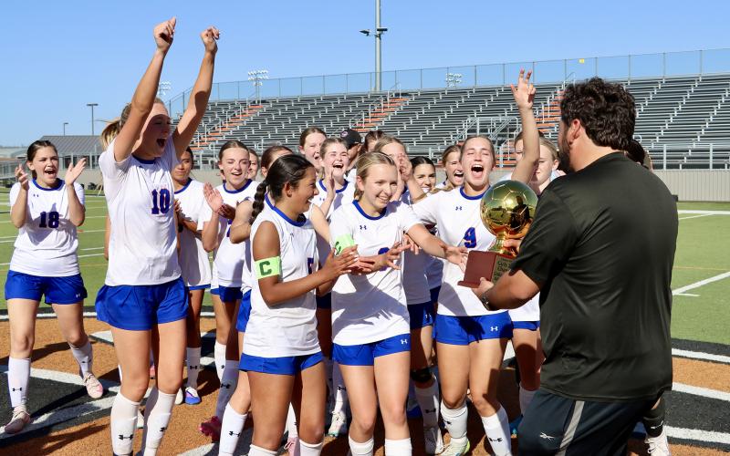(THOMAS WALLNER | THE GRAHAM LEADER) The Lady Blues hold no excitement back as they are handed their bi-district championship trophy after their win Thursday, March 19 over the Canyon Randall Lady Raiders in Burkburnett.