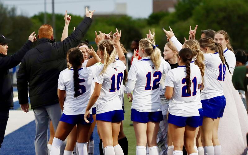 (THOMAS WALLNER | THE GRAHAM LEADER) Head coach Casey Weil, Assistant coach John Tuggle and the Lady Blues soccer team huddle up during the regional semifinal matchup with the Godley Ladycats. The Lady Blues fell 1-0 to the Ladycats, but were able to push farther into the playoffs than any other soccer team in school history.