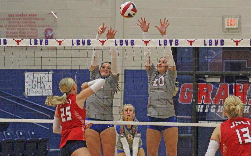 (ALEX HAVARDANSKY | THE GRAHAM LEADER) Madison Cauble and Emily Hughes team up for a block attempt Tuesday, Aug. 19 in their match against the Lady Indians. Unfortunately for Graham, the Lady Blues lost their home opener in three sets.