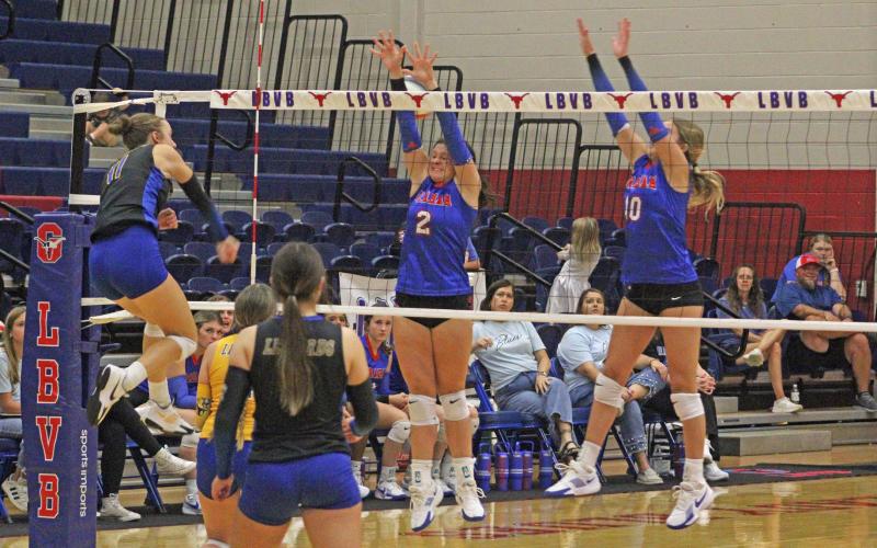 (ALEX HAVARDANKSY | THE GRAHAM LEADER) Madison Cauble, left, and Emily Hughes, right, go up for a block Friday, Sept. 12. The Lady Blues defeated the Lady Leopards in three sets during the game. 