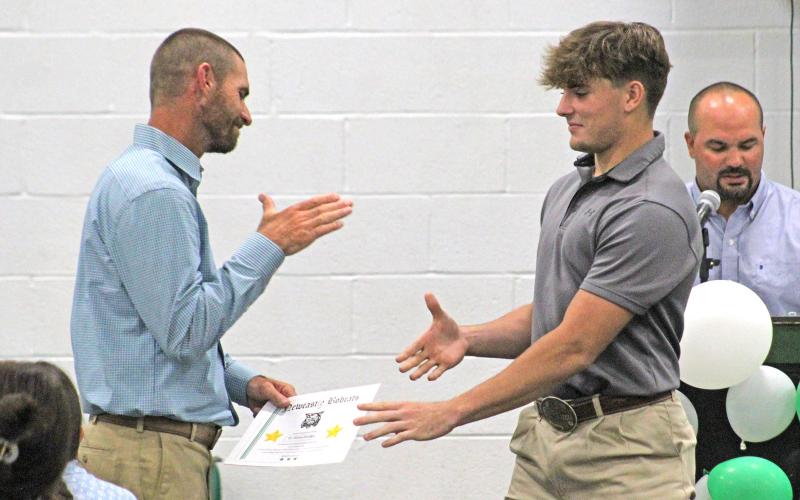 (ARCHIVE PHOTO | THE GRAHAM LEADER) Senior Ty Strawbridge shakes hands with coach James King as part of the football recognitions at the Newcastle sports banquet in May 2024. This year’s banquet will be held at 6 p.m. Friday, May 22 in the legacy gym.