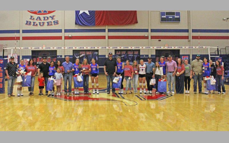 (ALEX HARVADANSKY | THE GRAHAM LEADER) The Lady Blues seniors and their families pose for a photo on senior night Tuesday, Sept. 23. The Lady Blues defeated the Lady Lions on this night in four sets. The senior night was a time to honor the players and their families.