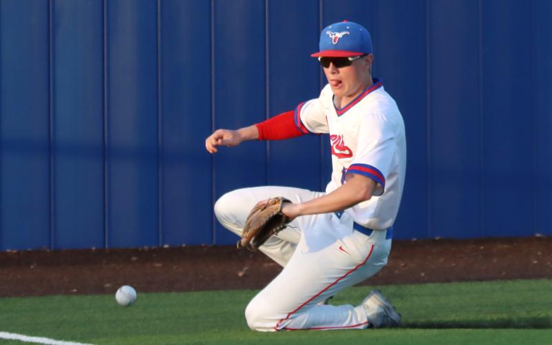 (THOMAS WALLNER | THE GRAHAM LEADER) Ayden McDougal slides to catch a hit to left field by the Brock Eagles during their first matchup against the Steers at home Tuesday, March 24. The team took on the Eagles again Friday, March 27 and fell 10-0.