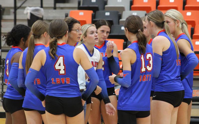 (ALEX HAVARDANSKY | THE GRAHAM LEADER) Lady Blues head coach Marci Faulk, and her team, talk strategy in between sets Tuesday, Aug. 12, against the Lady Bulldogs. The team went on to beat Burkburnett 3-2 in five sets.