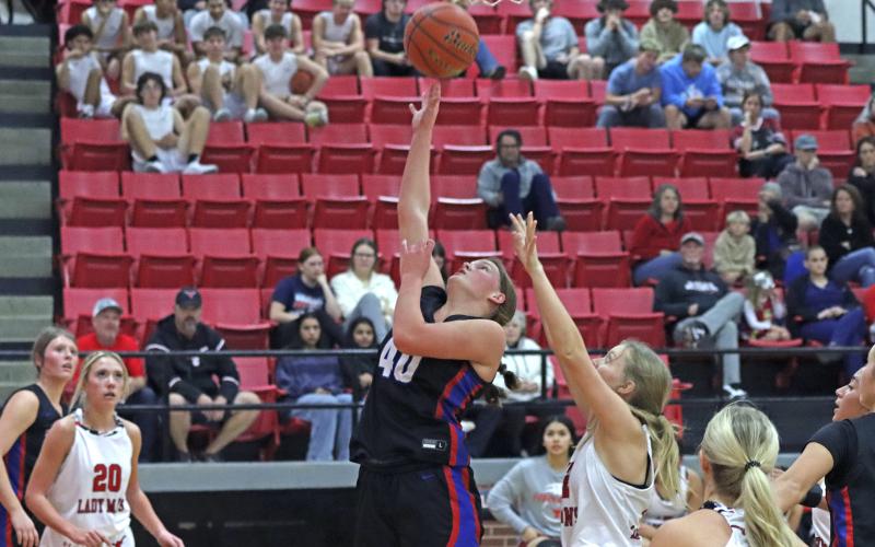 (TC GORDON | THE GRAHAM LEADER) Graham’s Addyson Weaver makes a close layup past Eastland defenders Tuesday, Dec. 3 in the Lady Blues’ 60-53 win over the Lady Mavs.