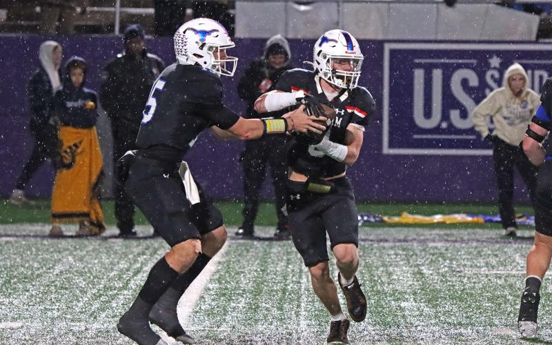 (TC GORDON | THE GRAHAM LEADER) Graham quarterback Ty Thompson (15) hands off to receiver Jace Gill (8) on a run play Friday, Dec. 6 in the Steers’ 12-10 triple overtime loss to Brock in the region final.