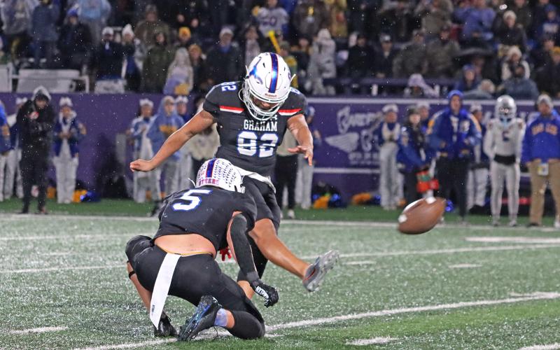 (TC GORDON | THE GRAHAM LEADER) Graham kicker Ozzy Trejo (82) boots a 45-yard field goal while holder Harison Brockway (5) keeps the ball steady for him Friday, Dec. 6. The Steers ended up losing the region final 12-10 in triple overtime to Brock.