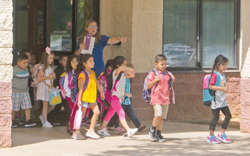 (FILE PHOTO | THE GRAHAM LEADER) A teacher at Pioneer Elementary School lets students out of the campus on the first day of school in 2019.