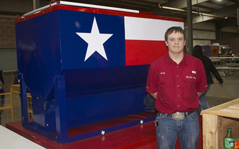 Coby Slater, of Olney FFA, stands with a cattle feeder that he built and exhibited in the Ag Mechanics division of the Young County Junior Livestock Show Thursday evening at the Young County Arena. Slater won the Ag Mechanics Showmanship Award with his feeder, which he said took about 150 hours to complete from start to finish.