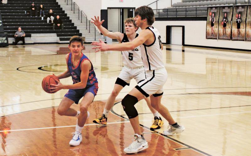 (MIKE WILLIAMS | THE GRAHAM LEADER) Steers junior Ben Lucas tries to pass out of a double-team during the second half of the Steers’ 73-42 loss Tuesday, Nov. 22 at Cleburne High School.