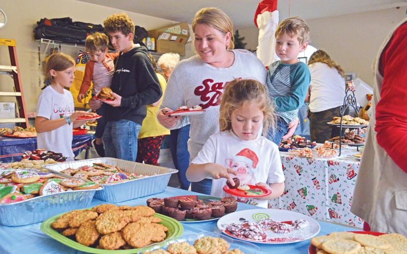 (THOMAS WALLNER | THE GRAHAM LEADER) Visitors to the annual Cookie Day event in 2021 pick out cookies from trays placed in the garage of Mary Braddock. The Cookie Day event has been a tradition for over 60 years in Graham from the Braddock family.