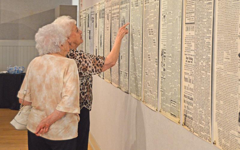 (THOMAS WALLNER | THE GRAHAM LEADER) Visitors to the Old Post Office Museum and Art Center look over old issues of The Graham Leader on display.