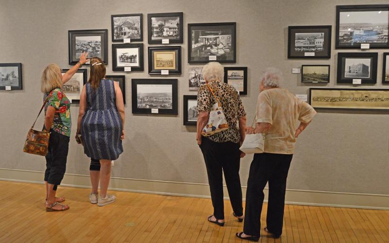 (THOMAS WALLNER | THE GRAHAM LEADER) Visitors to the Old Post Office Museum and Art Center look over old photos of Graham and Young County.