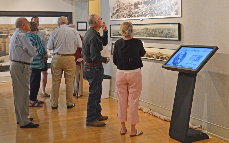 (THOMAS WALLNER | THE GRAHAM LEADER) Young County Judge John Bullock and Susan Smith look over a picture of the Graham downtown square Saturday, Sept. 24. Next to the two is a new touchscreen kiosk which displays the history of 10 people who made a difference in Graham’s history.