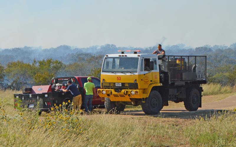 (MADDISON EVANS | THE GRAHAM LEADER) Volunteer Fire Department crew regroup from a grass off FM 61 in Young County Wednesday, Sept. 28.