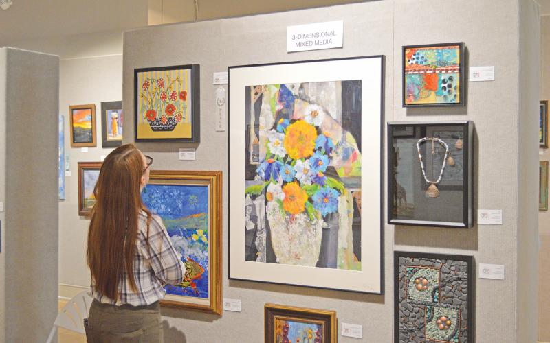 (THOMAS WALLNER | THE GRAHAM LEADER) A visitor to the Lake Country Art Show artists reception in 2021 looks over artwork on display at the Old Post Office Museum and Art Center. The show this year will be held from Wednesday, July 28 through Saturday, Sept. 10.