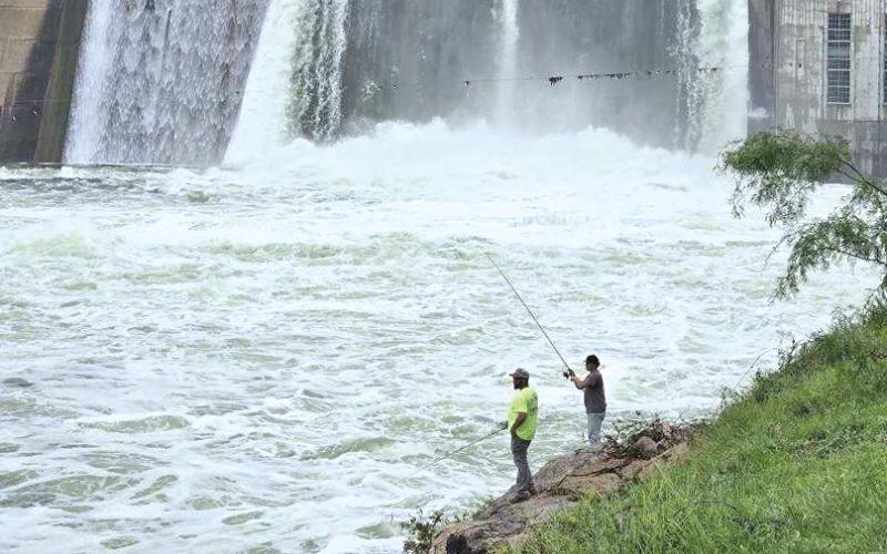(RON EISELE | CONTRIBUTED PHOTO) Fishermen cast lines at the base of the Possum Kingdom dam which has been opening its gates recently due to a large amount of rainfall in the area.