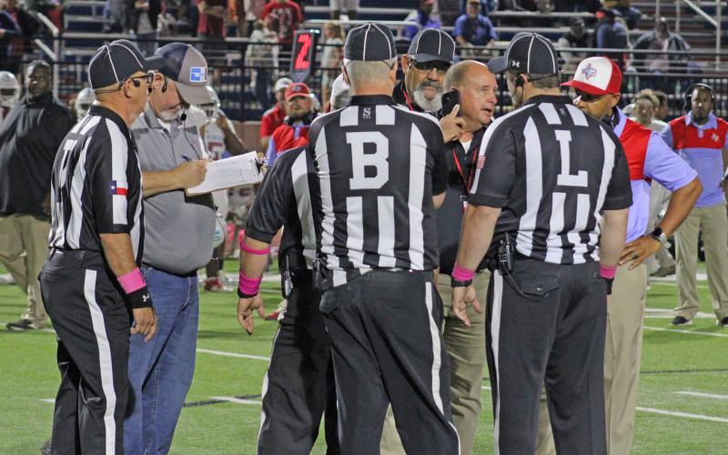 (MIKE WILLIAMS | THE GRAHAM LEADER) Graham ISD superintendent Sonny Cruse speaks with coaches and game officials following a fight in the third quarter during Friday's football game between the Graham Steers and Hirschi Huskies at Newton Field.