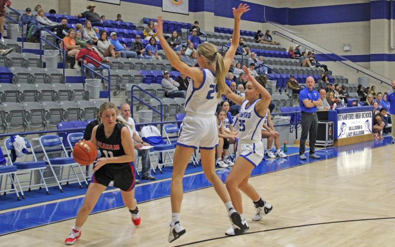 (MIKE WILLIAMS | THE GRAHAM LEADER) Maddie Franklin attempts to dribble out of a double team during the Lady Blues’ 44-22 loss at Stamford Tuesday Nov. 29. Franklin finished the game with four points.