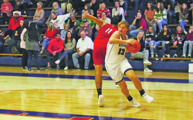 (MIKE WILLIAMS | THE GRAHAM LEADER) Kolby Spurlin drives past an Olney defender during the Steers’ 61-25 win over the Cubs Friday, Dec. 9 during the Red, White and Blue Tournament.