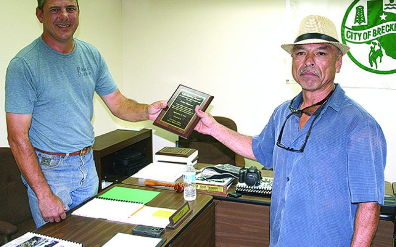 Breckenridge Mayor Jimmy McKay (left) presents Isbel Jimenez with a plaque from that city during the Oct. 4, 2015 city commissioner’s meeting. Jimenez, now of Graham, was awarded the Carnegie Hero Medal this week for saving a neighbor from a fire.  Leader photo by Tony Pilkington