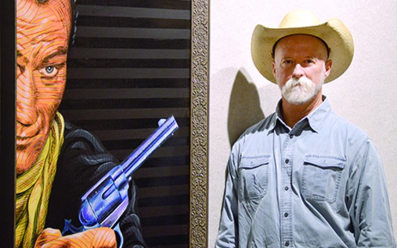 Artist Chuck Roach stands with his acrylic on masonite painting called ‘Bad Man – Pistol Up’ at his upcoming ‘Famous Outlaws’ show at the OPOMAC. The show runs from Sept. 10 through Nov. 11.
