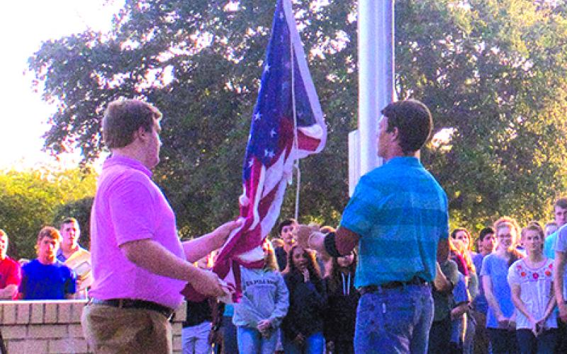 Graham High School Student Council officers Jeff Hazlett (left) and Kolton Gough raise the flag at the 79th annual DAR flag raising ceremony, held Wednesday in front of Graham High School. 