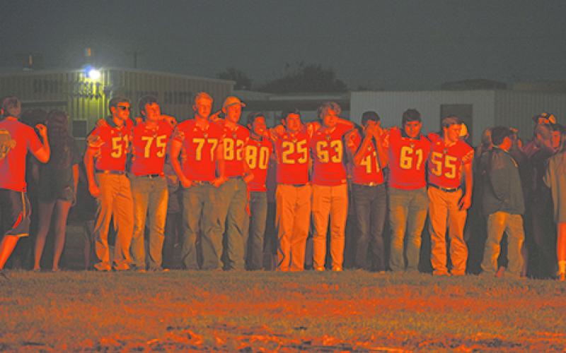 Members of the Graham Varsity Football team line up at the homecoming bonfire on Thursday and watch the towering flames. Players pictured from l-r include Jack Hays, Kolton Kinney, Smith Graham, Chance Hornsey, Jesus Hernandez, Kade Darrow, Connor Diemer, Ian Villa, Alfonso Duran and Hudson Peavy. 