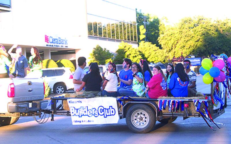 Members of the Graham Kiwanis Builders Club wave to the crowd during the Homecoming parade on Thursday evening.