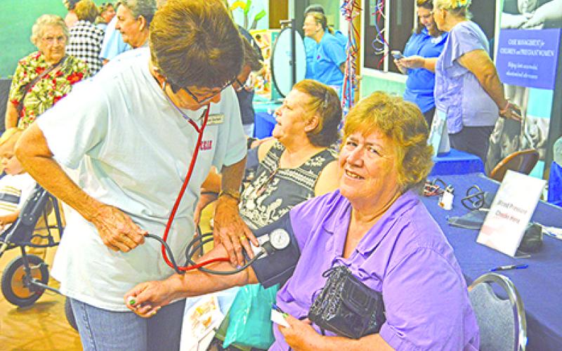 Roxie Durham, a home health aide from Young County Home Health, checks Joan Blakenship’s blood pressure at the annual Graham Community Health and Wellness Fair presented by Graham Regional Medical Center. 