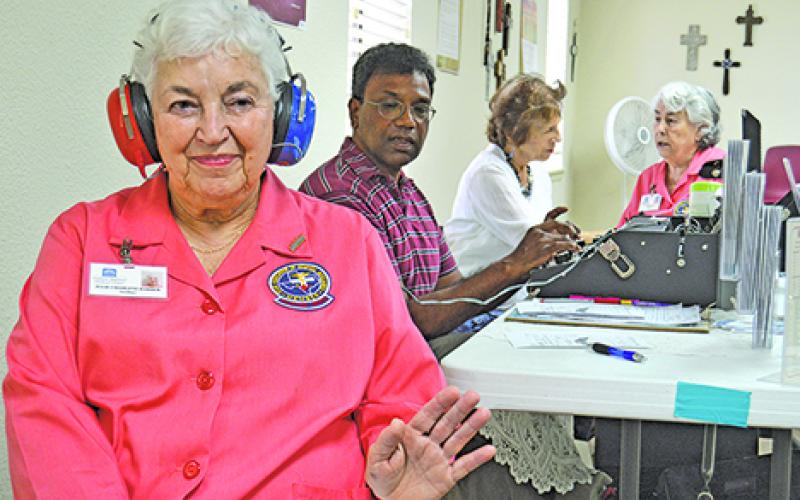 raham Regional Medical Center Auxiliary member Julie Harber puts her hand up during a hearing test at the the annual Graham Community Health and Wellness Fair, to signal to Mariano Fernandes who is administering the test that she can hear a response.