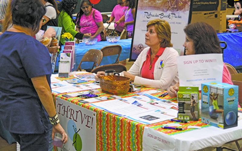 hysical therapist Vickie Keller (left) and office manager Johnnie Mead from Thrive Physical Therapy in Graham talk with visitors at the annual Graham Community Health and Wellness Fair at their booth.