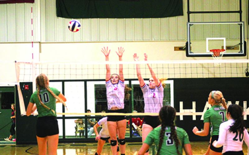 From left, Chloe Menard and Skylar Morris were able to block this shot during the Blues’ win over Iowa Park.	Leader photo by Travis Lisle