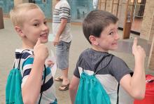 (CONTRIBUTED PHOTO | KELLY LAFARGE) Two participants in the Library of Graham Summer Reading Program receive backpacks with free books and goodies after filling out six weeks of reading logs. The program this year kicks off Wednesday, June 7.